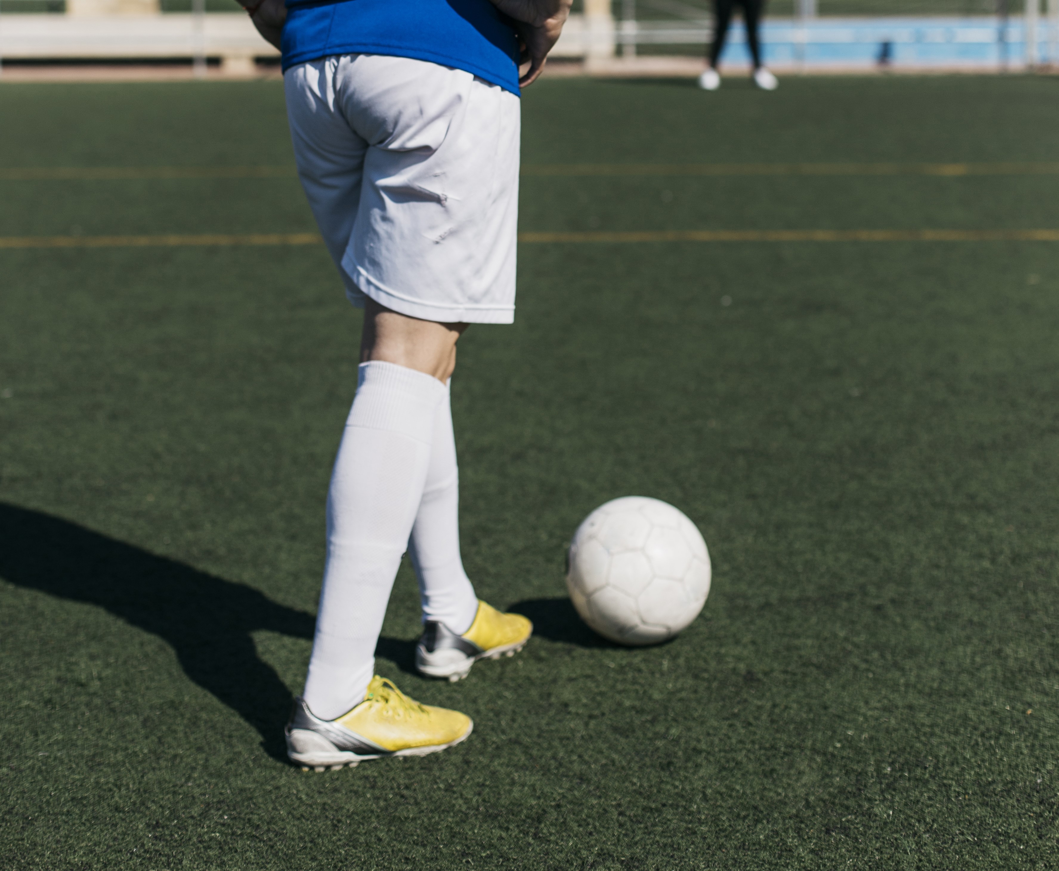 Football player standing with a ball on the pitch